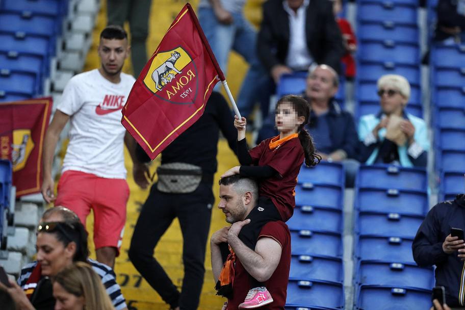 Una piccola tifosa sventola la bandiera della Roma. Ansa